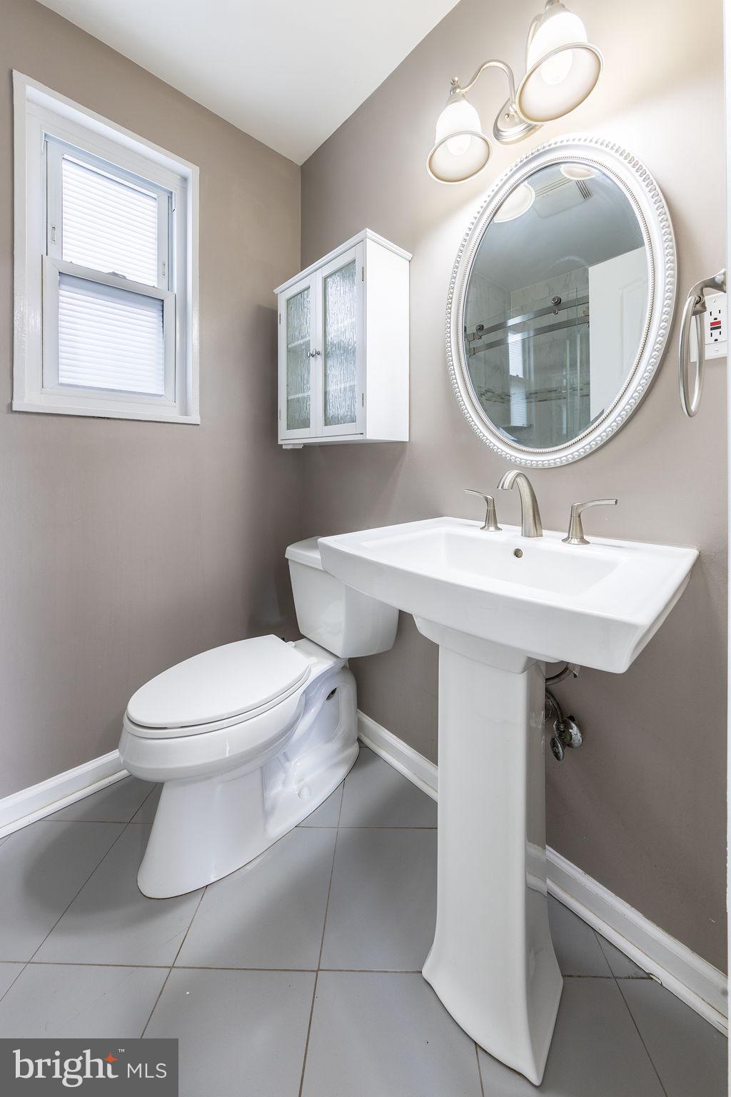 12112 Atherton Drive Silver Spring, MD 20902 - Photo 26 of 32 a bathroom with a toilet a sink and mirror