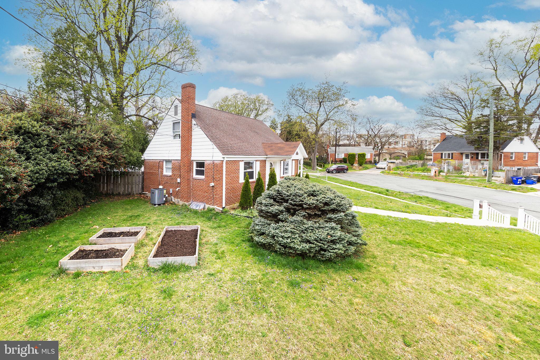 12112 Atherton Drive Silver Spring, MD 20902 - Photo 31 of 32 a front view of a house with a garden and trees