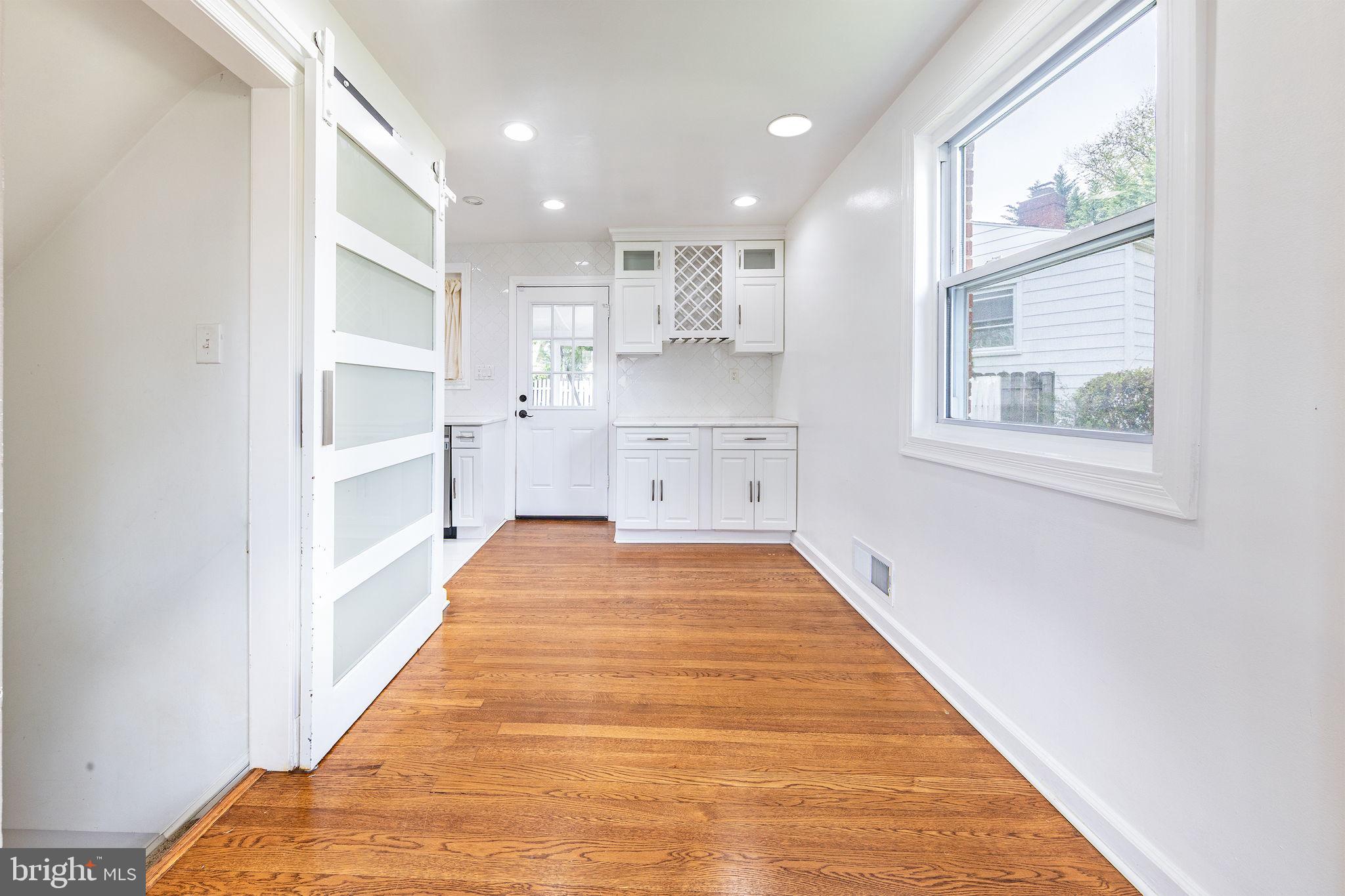 12112 Atherton Drive Silver Spring, MD 20902 - Photo 4 of 32 a view of a kitchen with kitchen island a window a wooden floor and a window