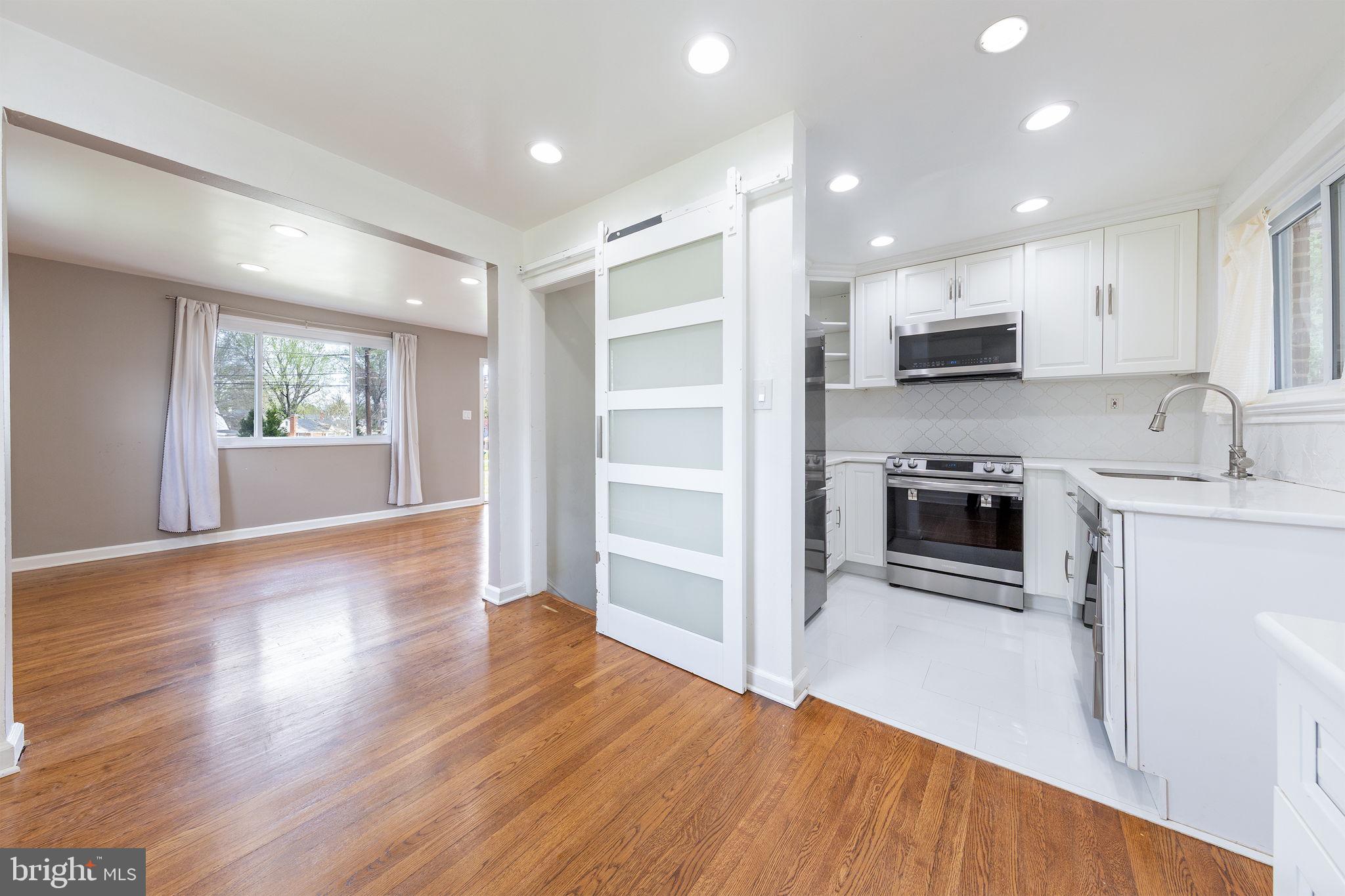 12112 Atherton Drive Silver Spring, MD 20902 - Photo 5 of 32 a kitchen with microwave a stove and wooden floor