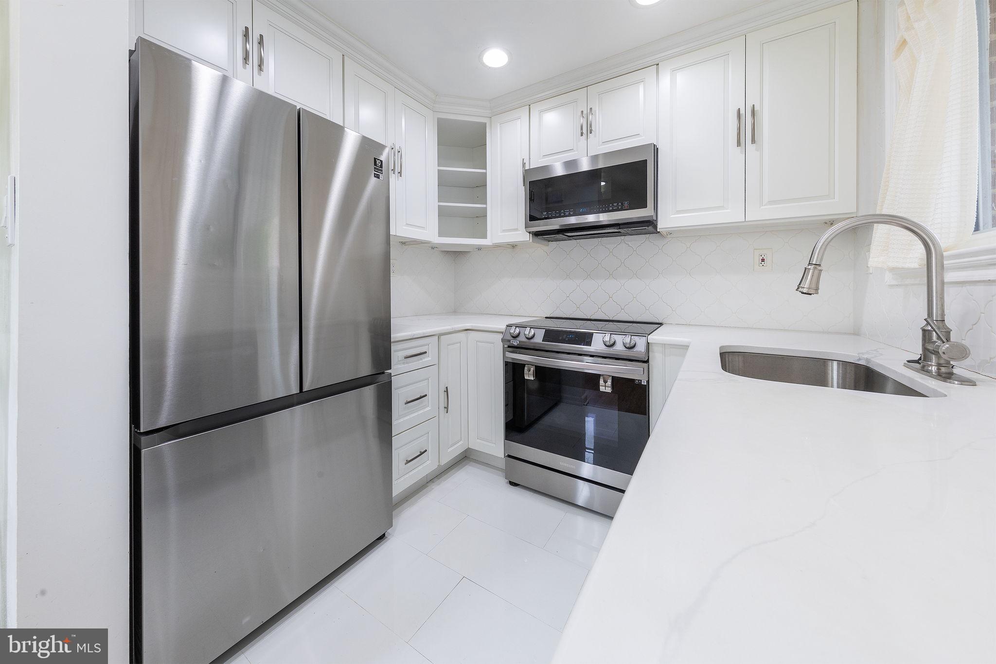 12112 Atherton Drive Silver Spring, MD 20902 - Photo 6 of 32 a kitchen with stainless steel appliances a refrigerator sink and microwave