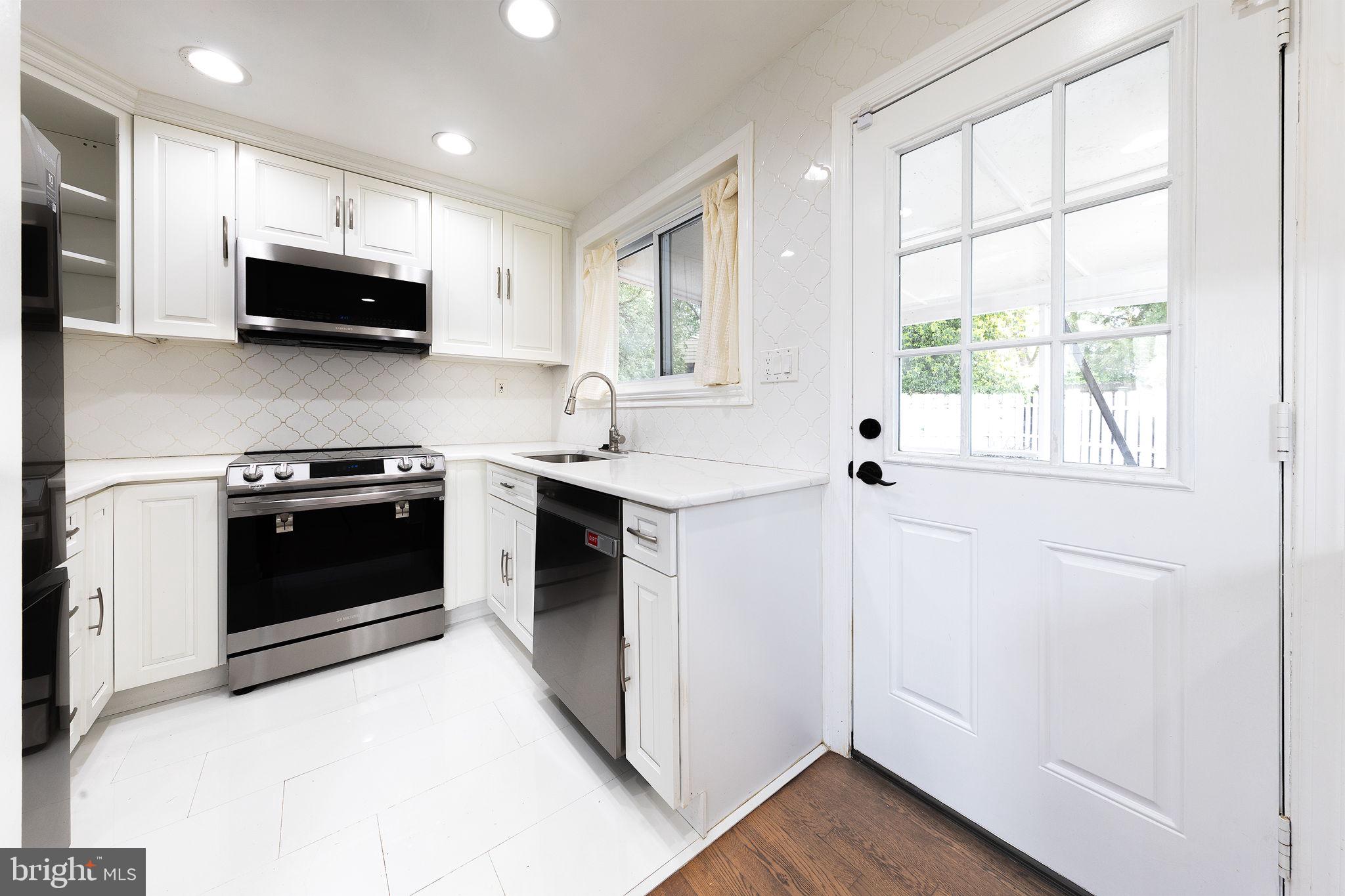 12112 Atherton Drive Silver Spring, MD 20902 - Photo 8 of 32 a kitchen with stainless steel appliances a stove a sink and a microwave