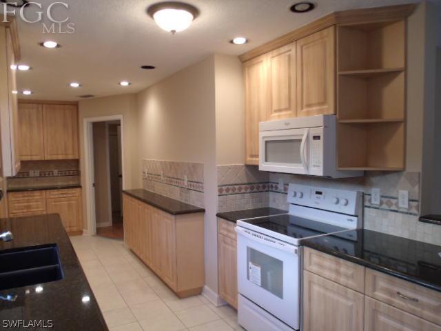 17476 Duquesne Road Fort Myers, FL 33967 - Photo 3 of 23 a kitchen with stainless steel appliances granite countertop a stove a sink and a refrigerator