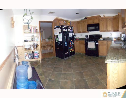 768 Old Raritan Road Edison, NJ 08820 - Photo 4 of 10 a kitchen with stainless steel appliances granite countertop a refrigerator and a wooden floor