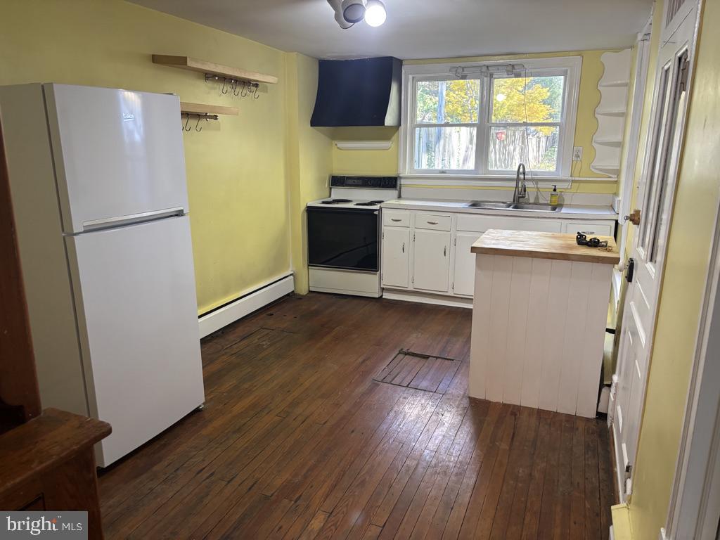 121 East 4th Street Frederick, MD 21701 - Photo 5 of 21 a kitchen with a refrigerator a sink wooden floor and a window
