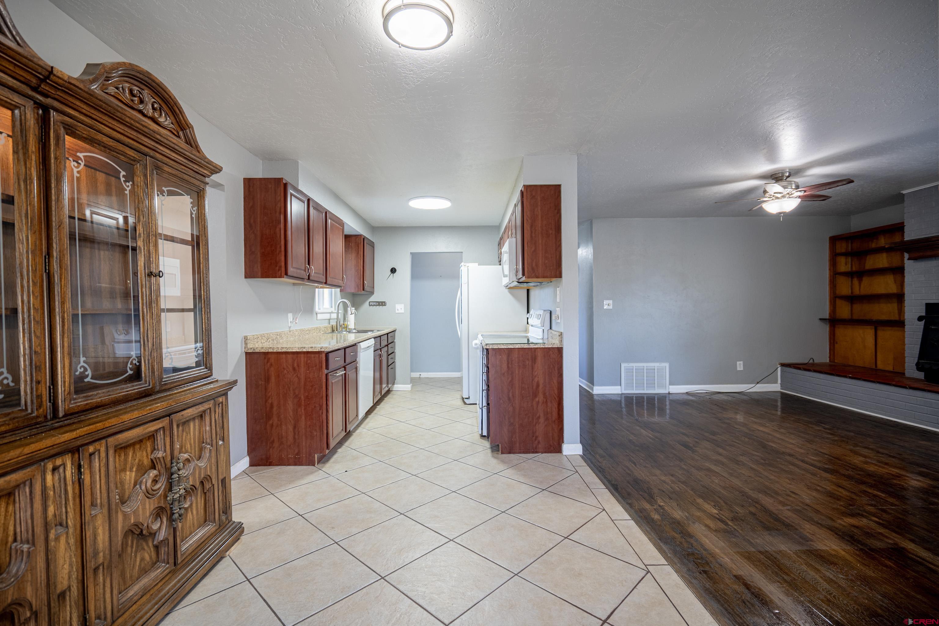 1702 East MacArthur Avenue Cortez, CO 81321 - Photo 7 of 42 a open kitchen with kitchen island granite countertop a sink and a stove top oven