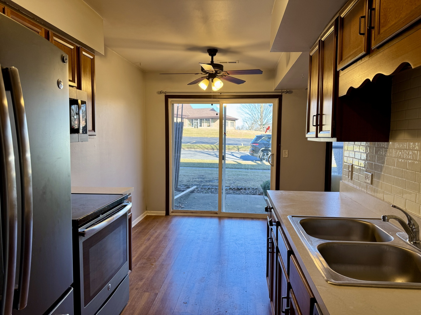 412 St Johns Road, Unit D Woodstock, IL 60098 - Photo 7 of 19 a kitchen with stainless steel appliances granite countertop a refrigerator a sink and a stove