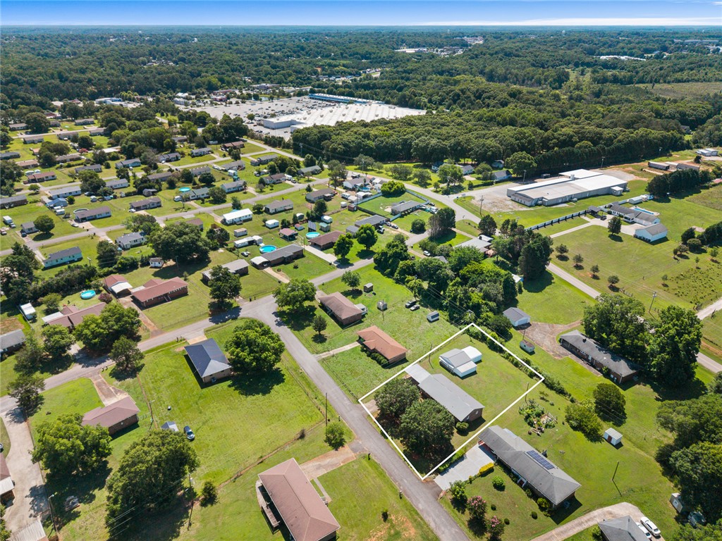 312 Edwards Drive Anderson, SC 29626 - Photo 39 of 44 An aerial perspective reveals a residential community nestled amidst verdant landscapes, with a prominent commercial property in the distance.