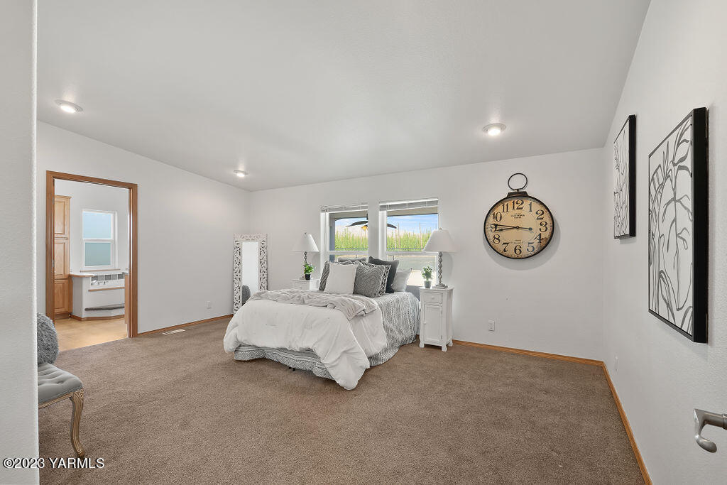 1305 Faucher Road Moxee, WA 98936 - Photo 22 of 40 a bed room with a bed and a large mirror