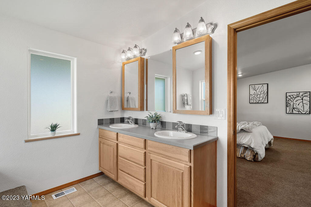 1305 Faucher Road Moxee, WA 98936 - Photo 25 of 40 a en suite bathroom with a double vanity sink and a mirror