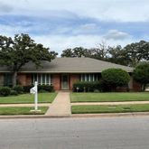 a front view of a house with a yard and trees