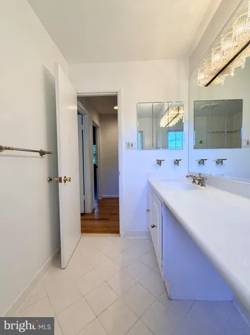 a spacious bathroom with a double vanity sink a mirror and a shower