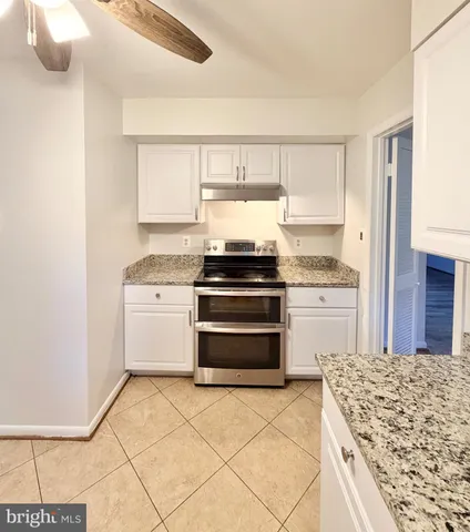 a kitchen with a stove top oven and cabinets