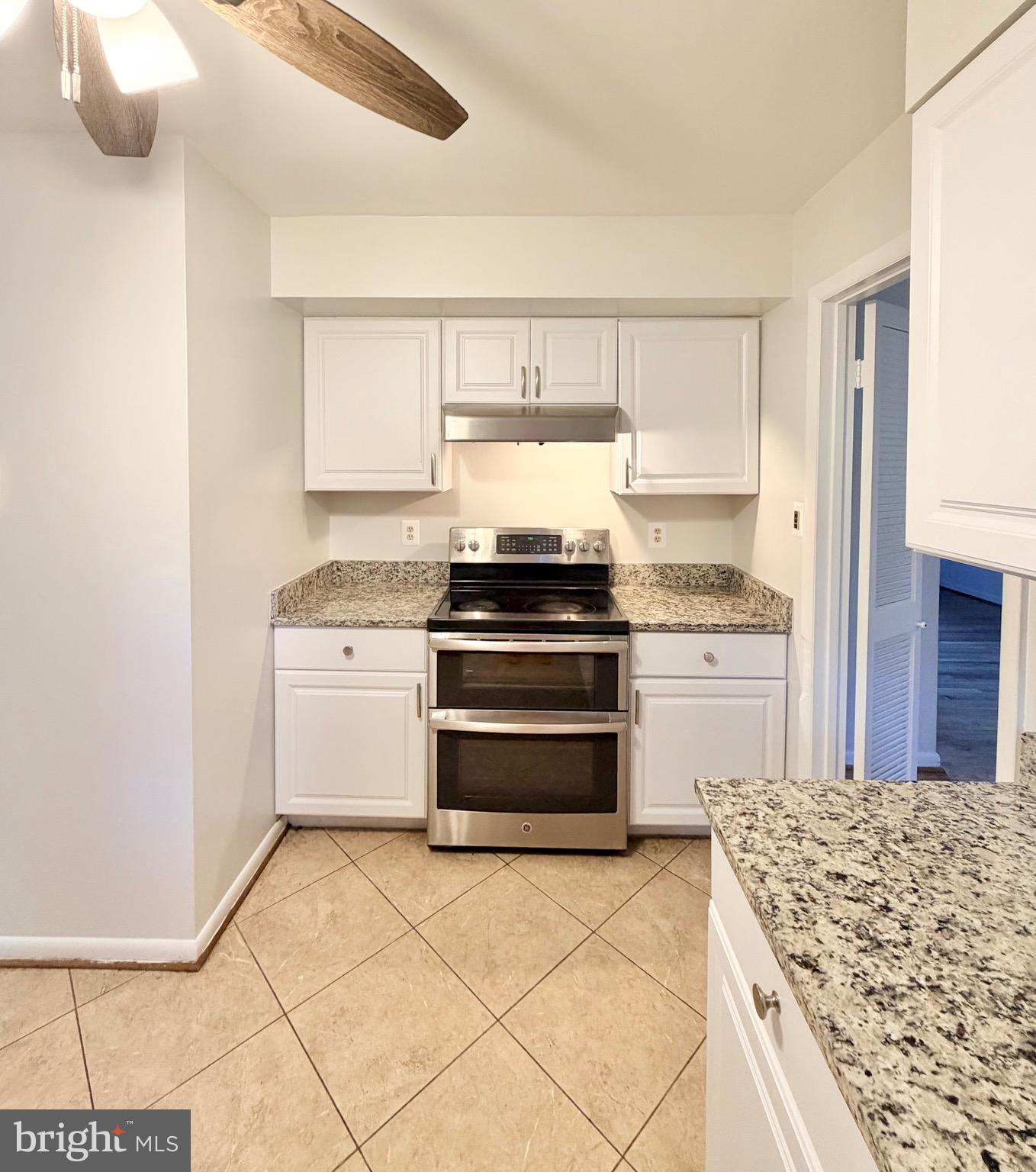 9513 Stevebrook Road Fairfax, VA 22032 - Photo 7 of 37 a kitchen with a stove top oven and cabinets