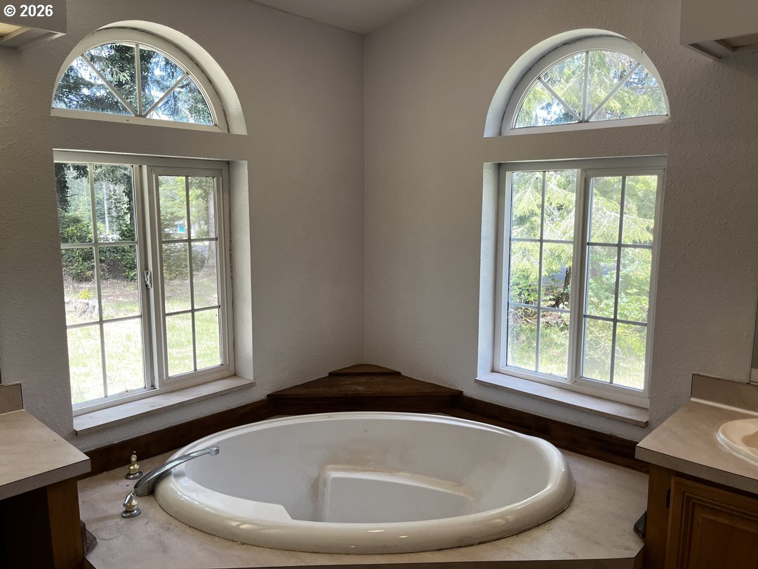 83411 Clear Lake Road Florence, OR 97439 - Photo 31 of 47 a bath tub sitting in a bathroom next to a window