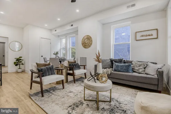 a living room with furniture and a wooden floor