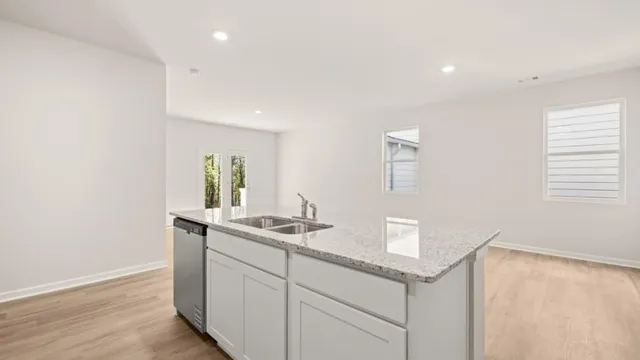 a kitchen with a sink cabinets and wooden floor