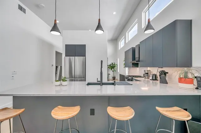 a kitchen with stainless steel appliances granite countertop a table chairs sink and cabinets