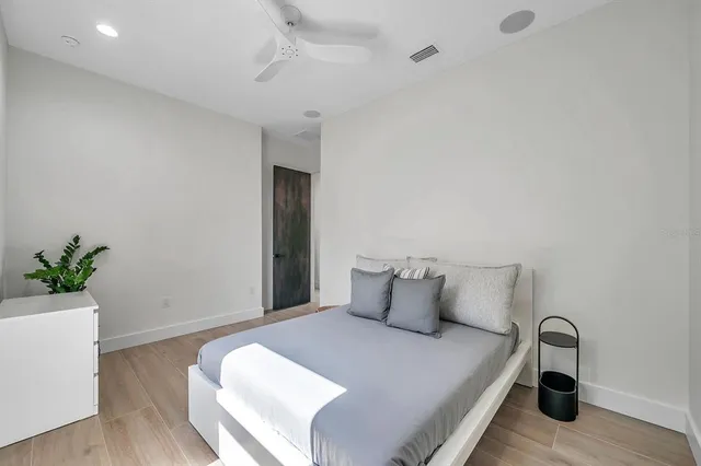 a bedroom with a bed and a potted plant
