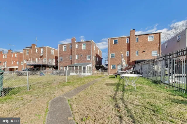 a view of a swimming pool with a lawn chairs and a big yard