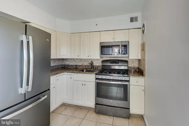 a kitchen with stainless steel appliances granite countertop a refrigerator stove and sink