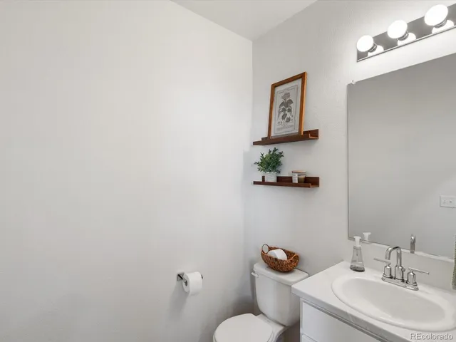 a bathroom with a sink mirror vanity and toilet
