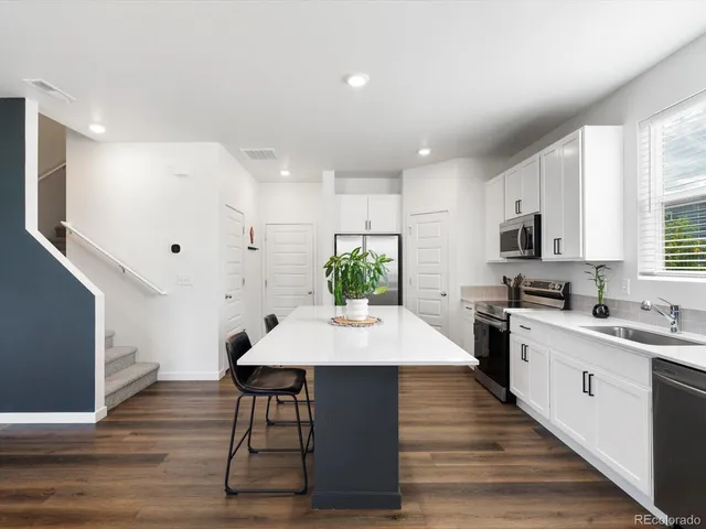 a kitchen with a table chairs sink and cabinets