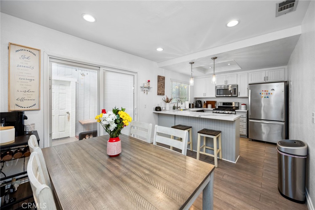 15251 Leffingwell Road, Unit 8 Whittier, CA 90604 - Photo 7 of 30 a kitchen with stainless steel appliances granite countertop a refrigerator a stove top oven a sink dishwasher and a dining table with wooden floor