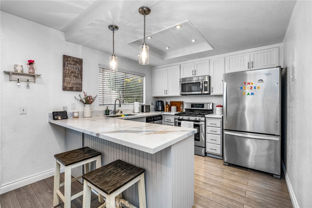 15251 Leffingwell Road, Unit 8 Whittier, CA 90604 - Photo 8 of 30 a kitchen with kitchen island a sink refrigerator and microwave