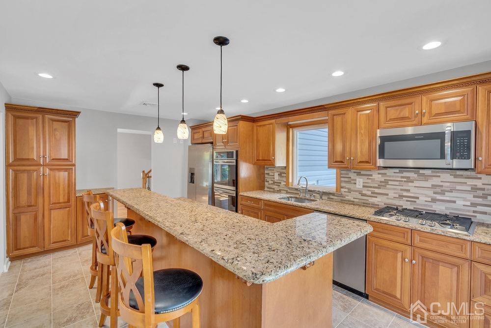 7 Bruning Road East Brunswick, NJ 08816 - Photo 15 of 20 a kitchen with granite countertop kitchen island stainless steel appliances a sink stove and refrigerator