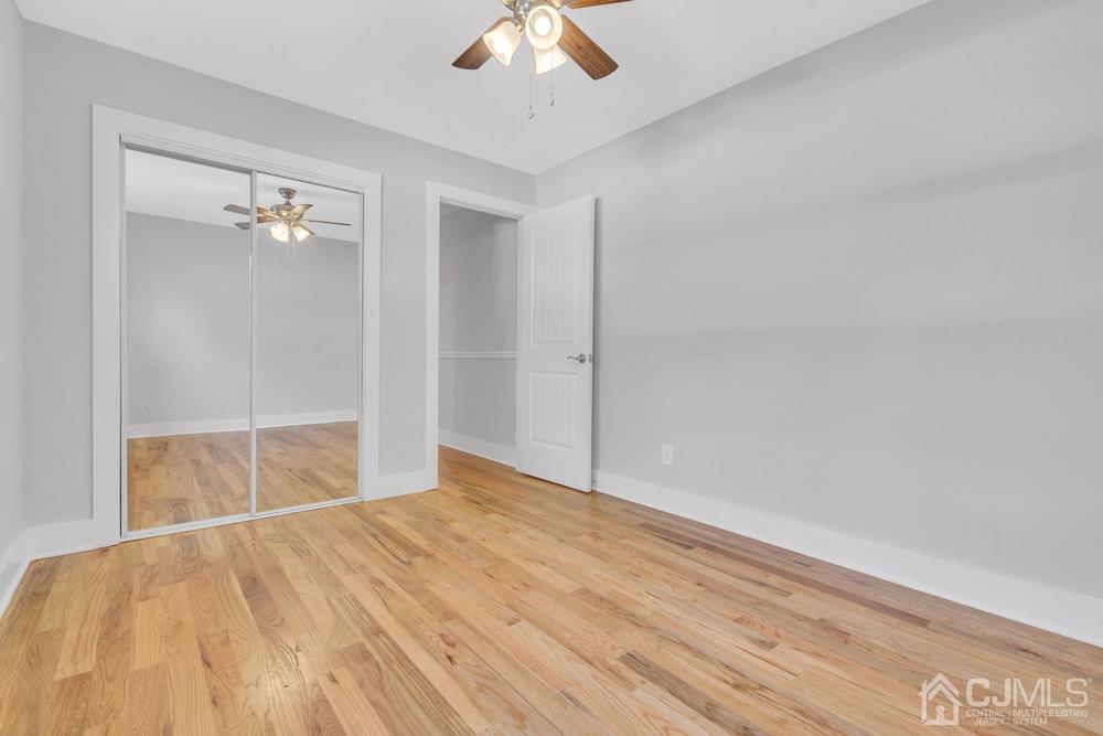 7 Bruning Road East Brunswick, NJ 08816 - Photo 8 of 20 an empty room with a ceiling fan and wooden floor
