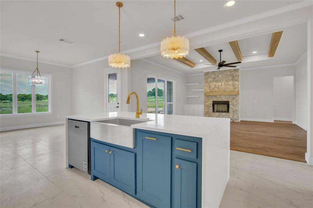 1028 Henry Way Springtown, TX 76082 - Photo 11 of 40 a kitchen with a sink dishwasher a dining table and chairs with wooden floor