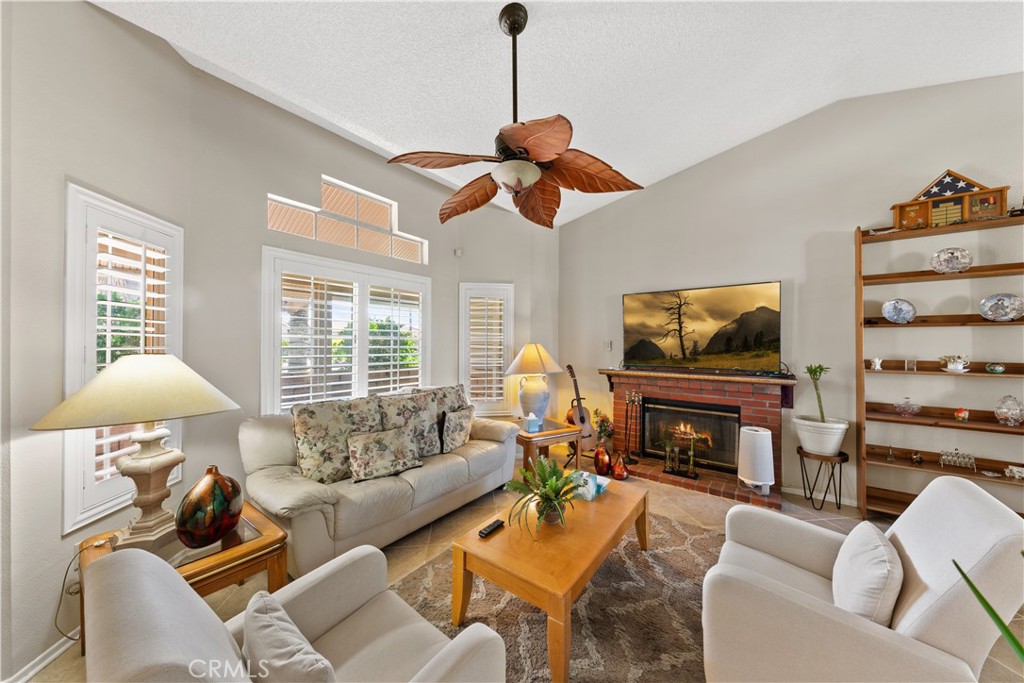 26592 Braddock Road Menifee, CA 92586 - Photo 4 of 23 a living room with furniture a fireplace and a flat screen tv