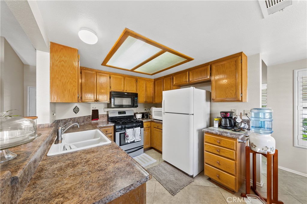 26592 Braddock Road Menifee, CA 92586 - Photo 7 of 23 a kitchen that has a sink and a refrigerator