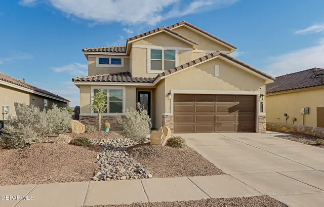 a front view of a house with a yard and garage