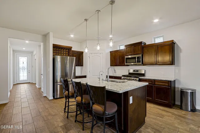 a kitchen with granite countertop cabinets stainless steel appliances and wooden floor