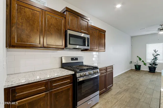 a kitchen with granite countertop cabinets stainless steel appliances and a counter space
