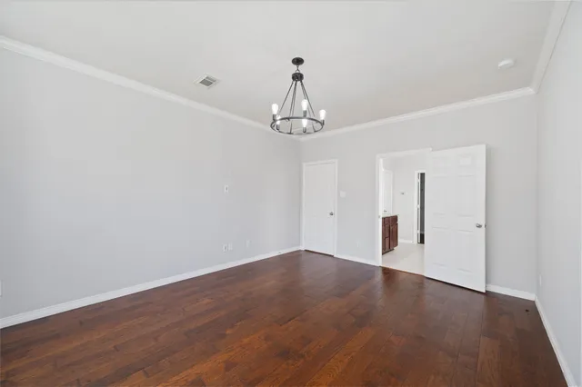 a view of a chandelier in big room and wooden floor