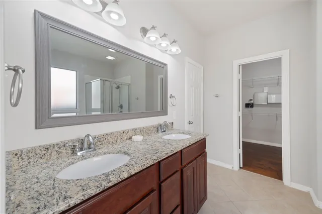 a bathroom with a granite countertop sink a large mirror and a shower