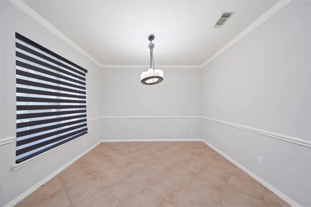 a view of a room with a hanging light and hardwood