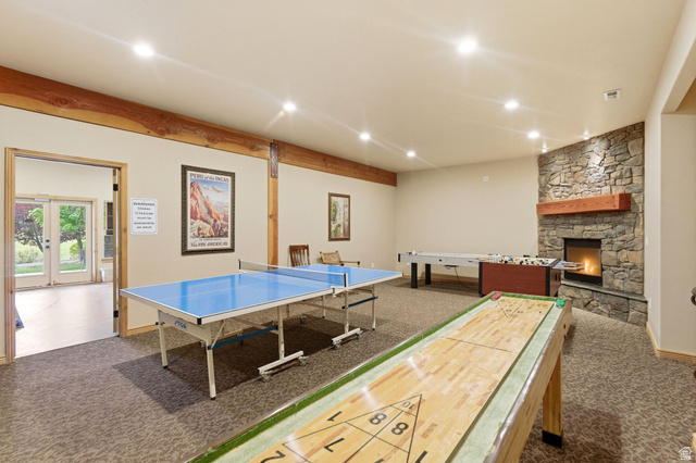 3634 North Huntsman Path, Unit C203 Eden, UT 84310 - Photo 18 of 27 Spacious recreation room featuring recessed lighting, exposed wood beams, and a stone-clad fireplace with a wood mantel