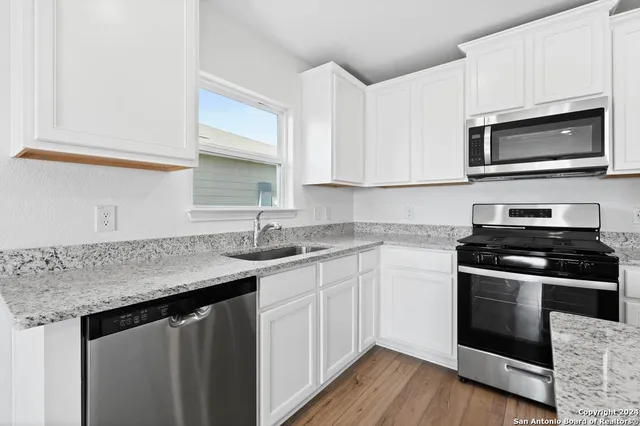 a kitchen with a refrigerator sink and cabinets