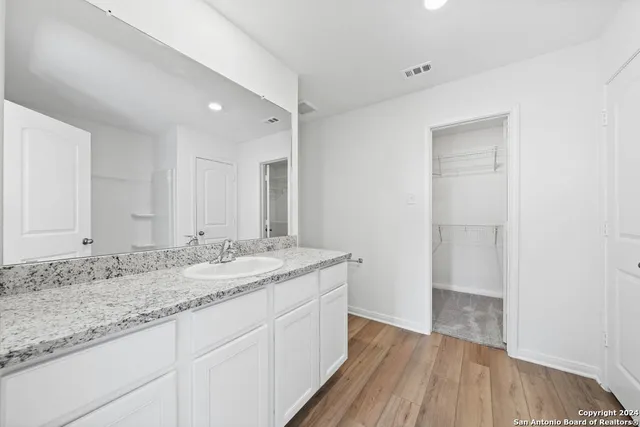 a bathroom with a granite countertop sink and mirror with bathtub