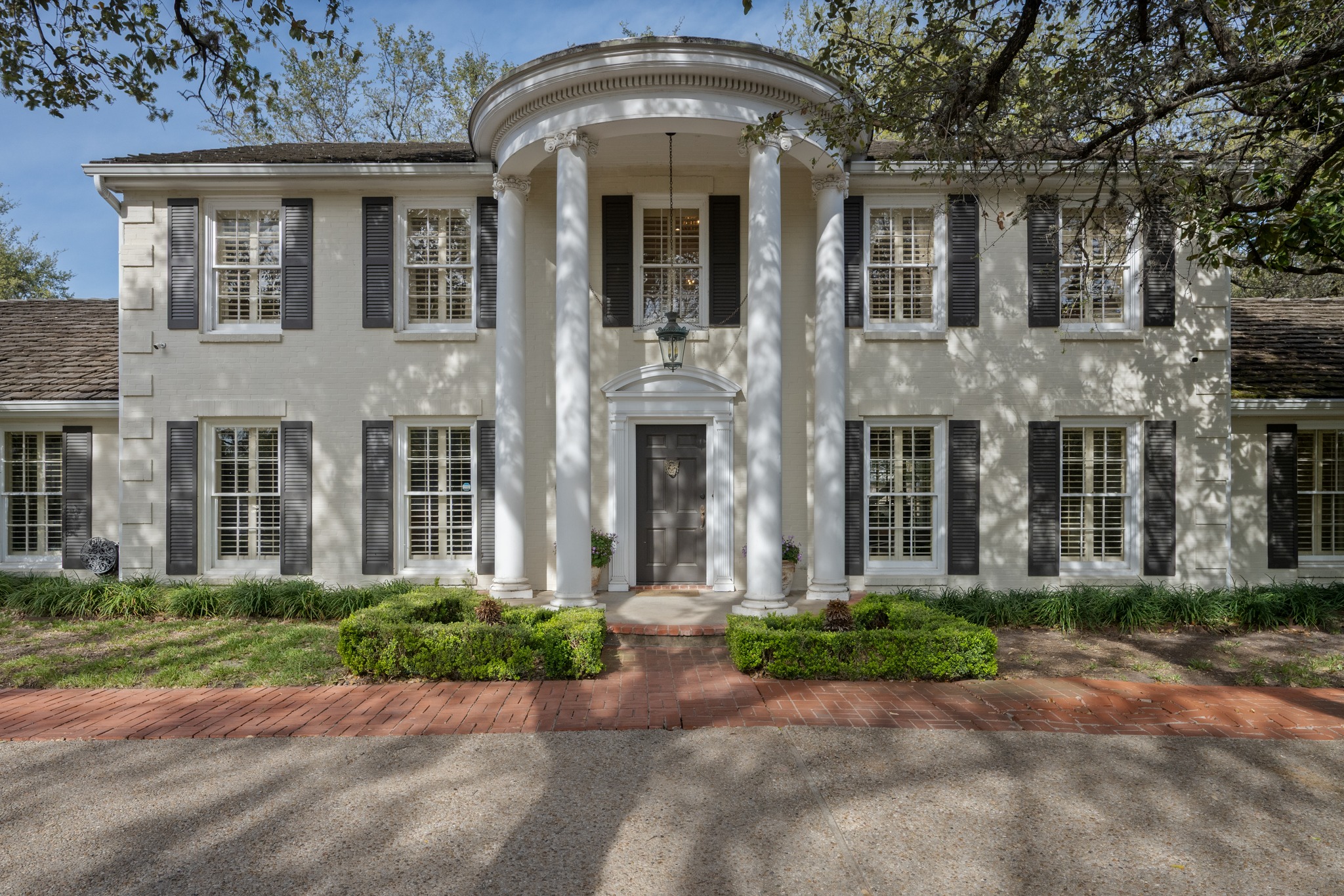 front view of a brick house with a yard
