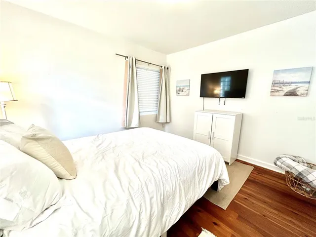 a bedroom with a bed and flat screen tv