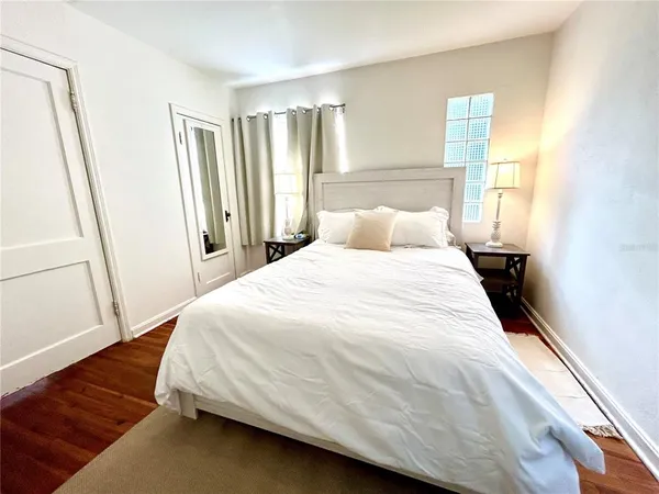 a large bed sitting in a bedroom next to a window