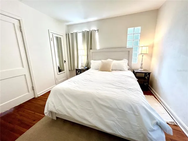 a large bed sitting in a bedroom next to a window