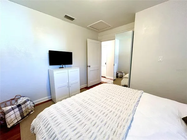 a bedroom with a bed and a flat screen tv