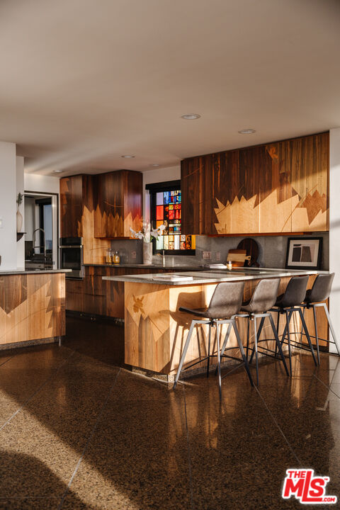 4 Yawl Street Marina del Rey, CA 90292 - Photo 7 of 34 a kitchen with stainless steel appliances granite countertop a stove top oven a dining table and chairs with wooden floor