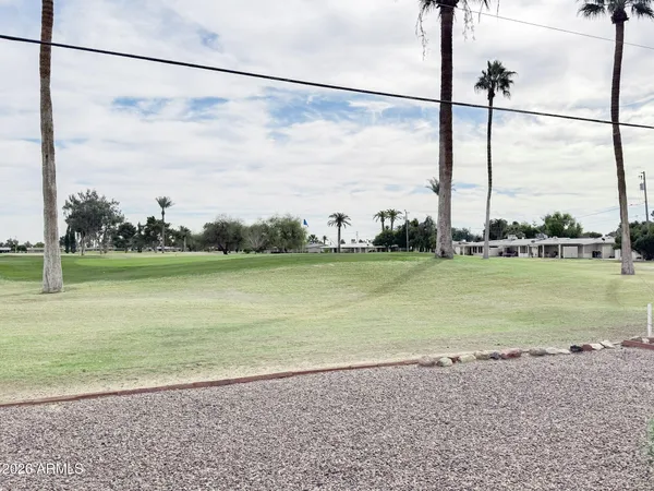 a view of a lake with a big yard next to a road